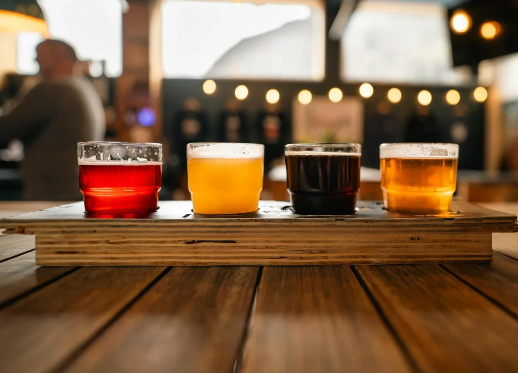 Variety of beer styles in different glasses arranged on a wooden bar