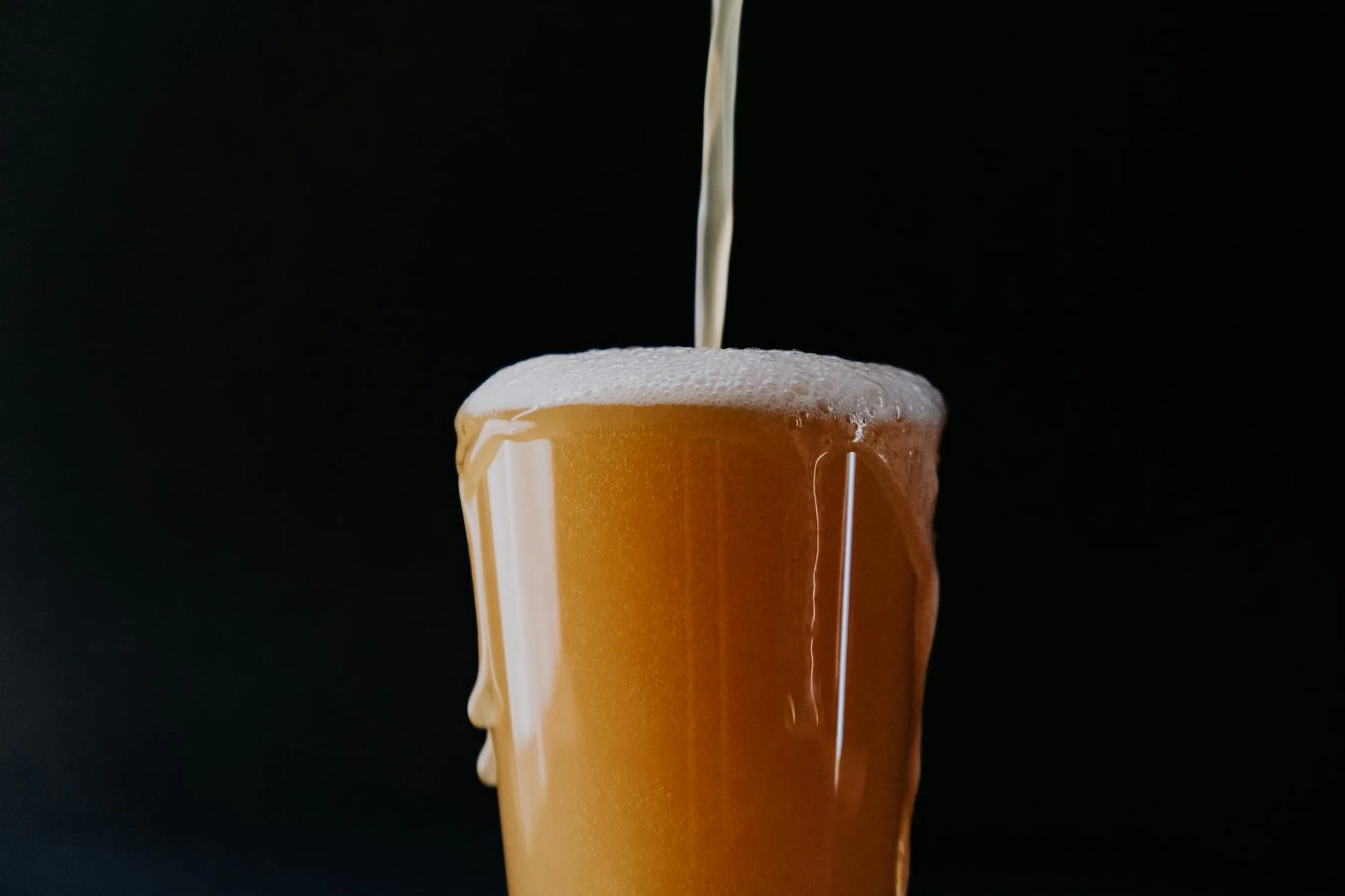 Golden beer being poured into a glass