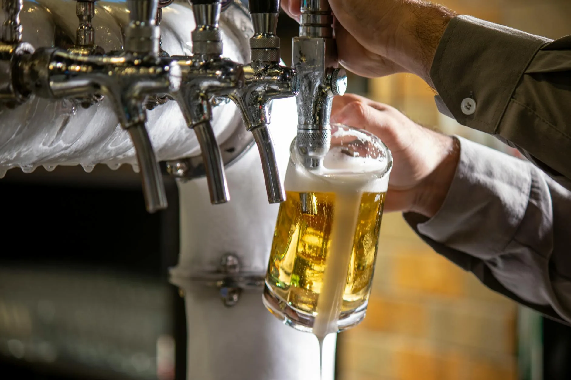 Amber craft beer in a pint glass at a bar tap