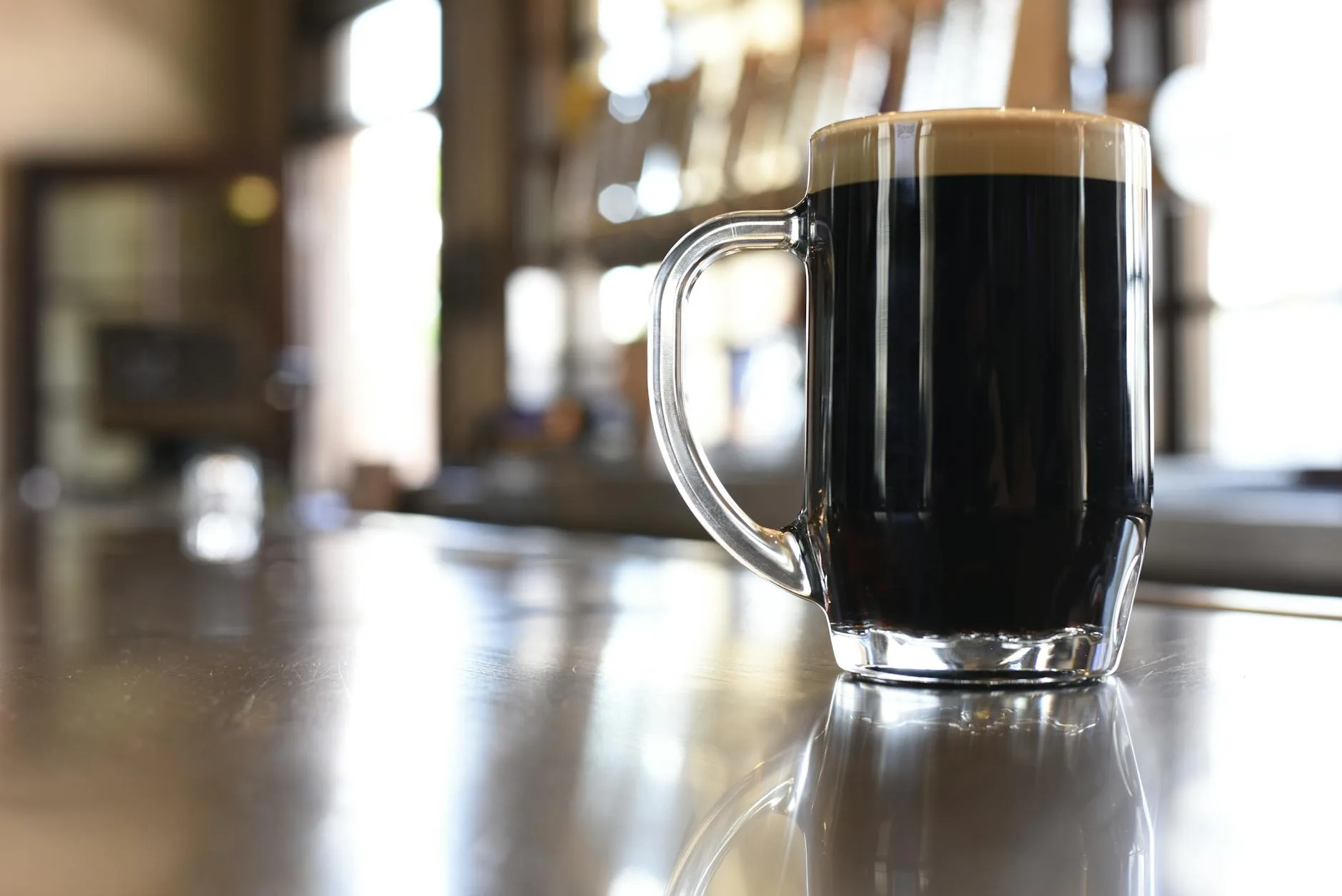 Dark stout beer with a thick creamy foam head in a glass