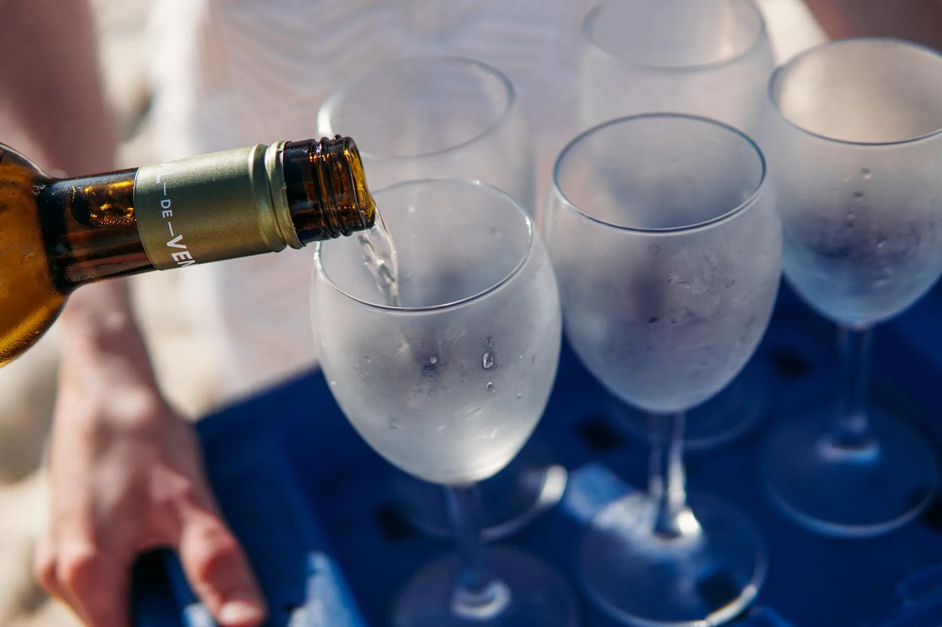 White wine being poured into chilled glasses