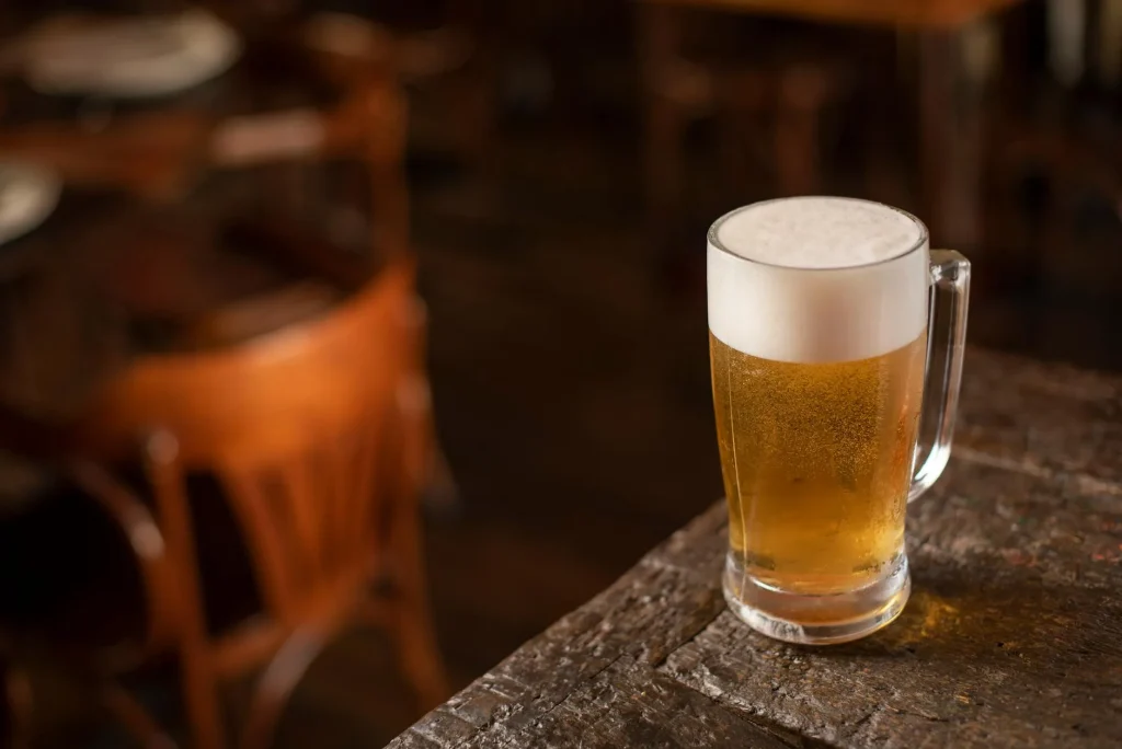 Glass of amber homebrew craft beer on a wooden table