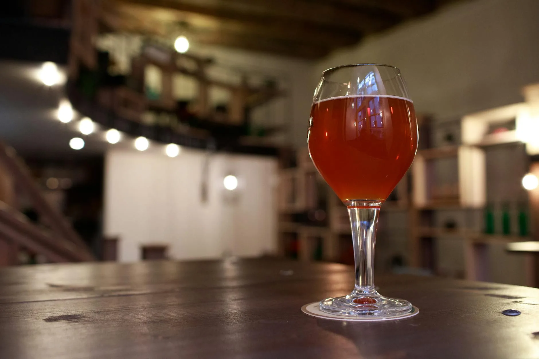 Glass of amber IPA craft beer on a wooden table