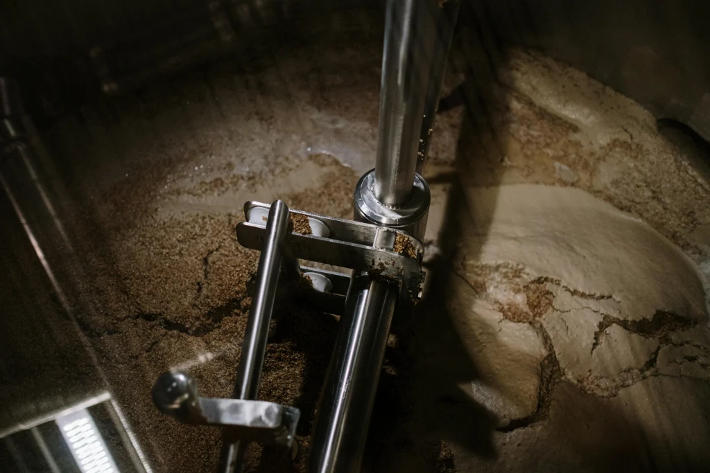 Overhead view of grain and water mixing during the mashing process in a homebrew setup