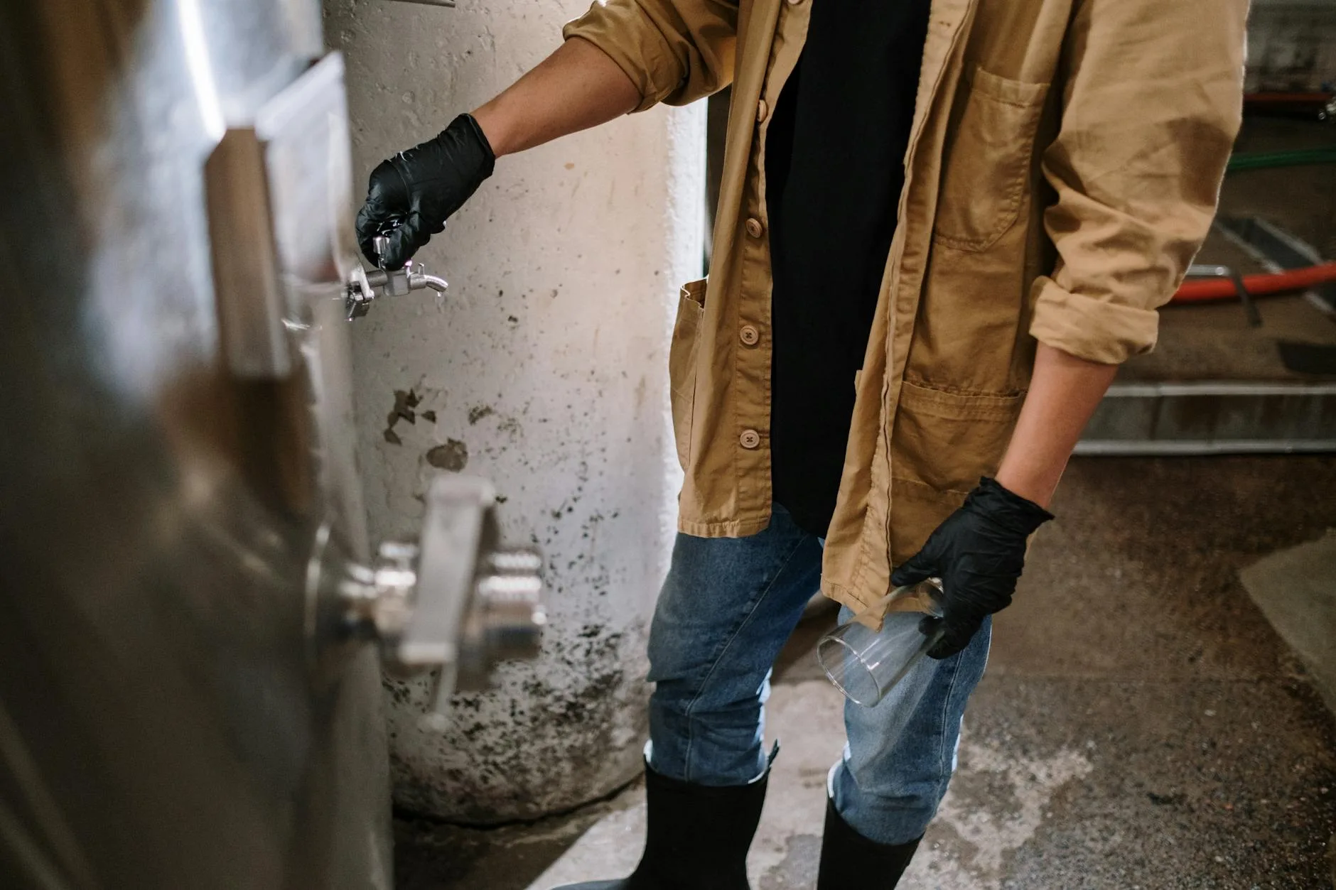 Brewer sampling from a tank valve during brewing