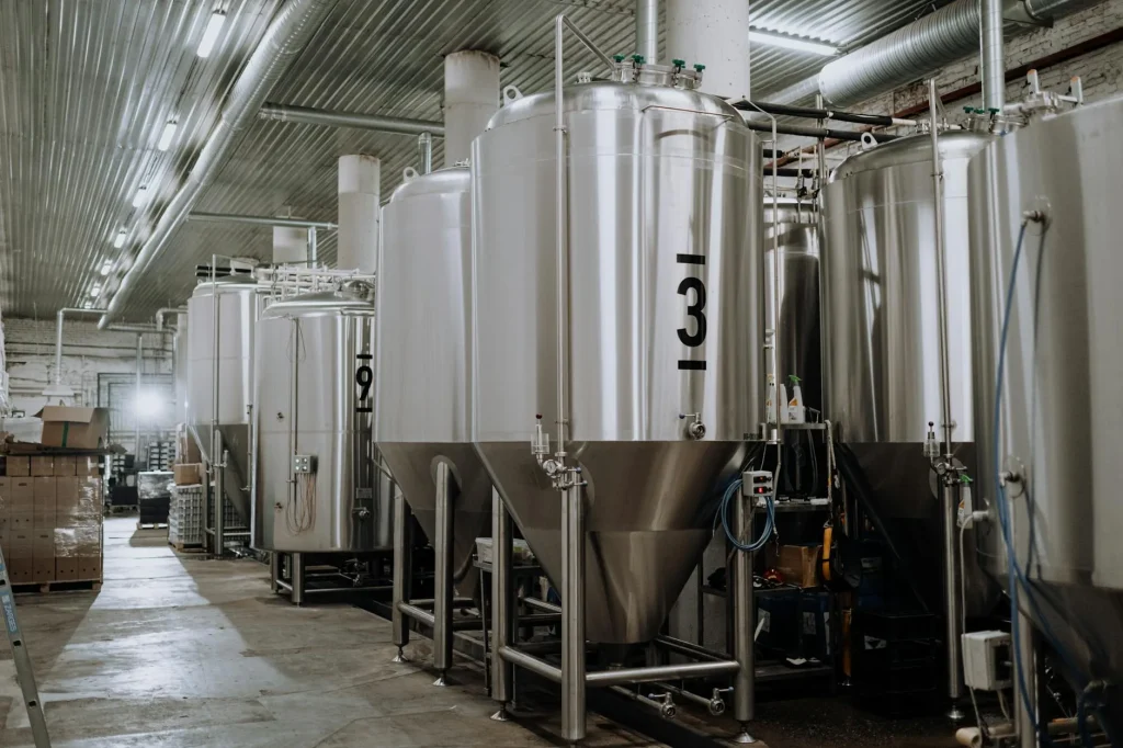 Home beer brewing equipment including fermenter and bottles on a kitchen worktop