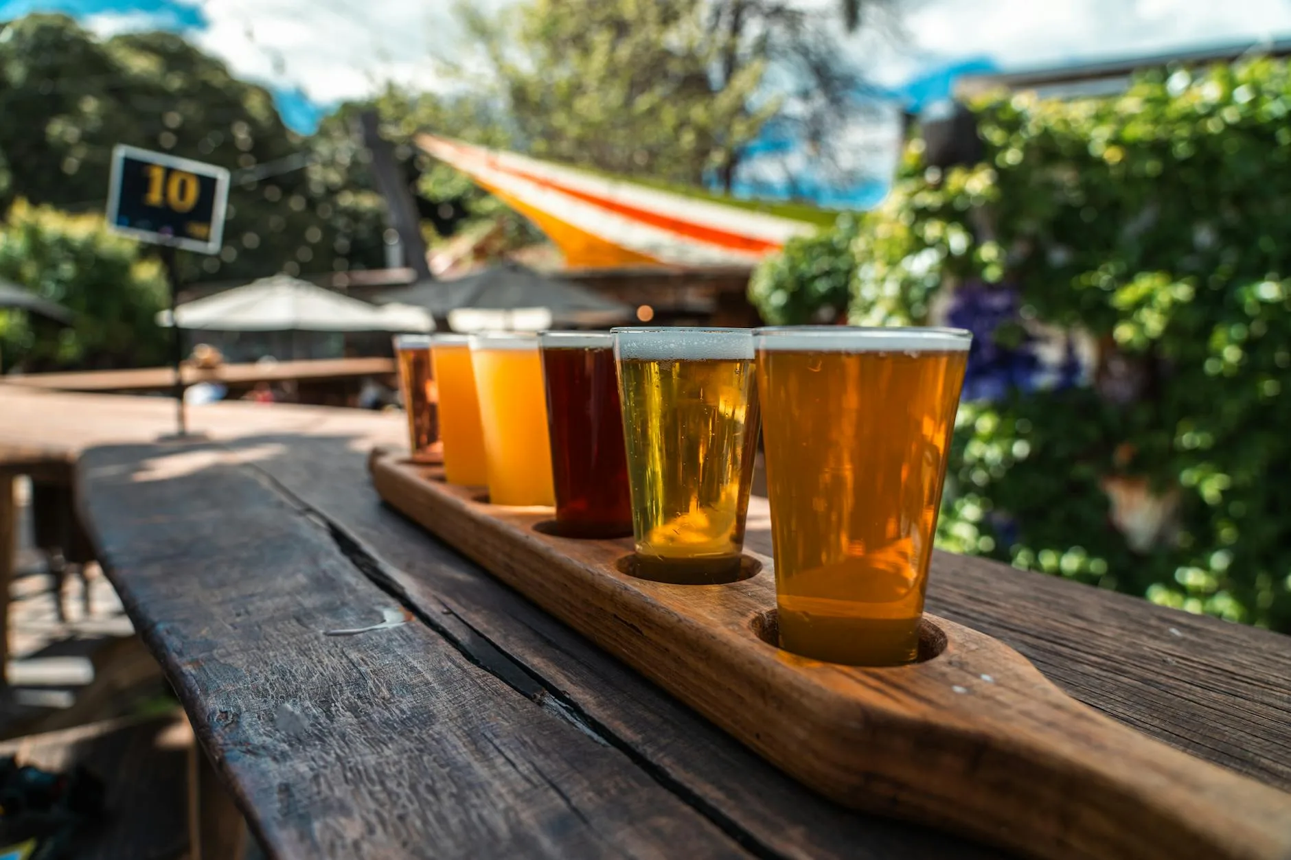Tasting craft beer from a flight of glasses on a wooden board