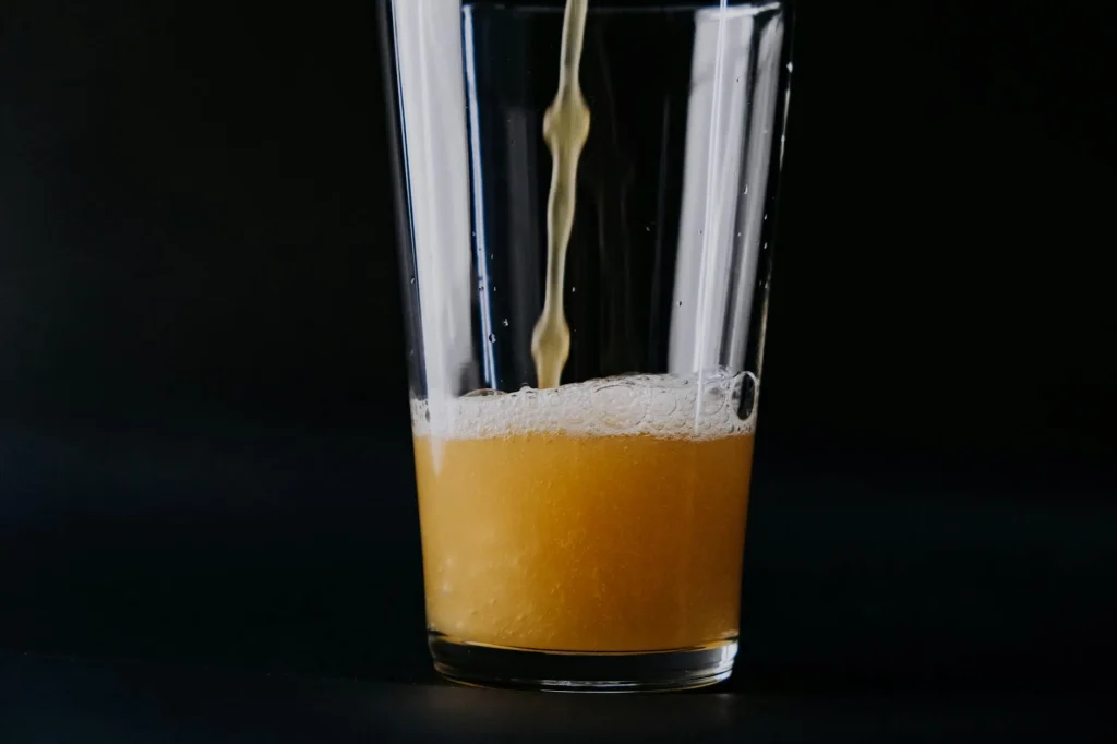 Hazy golden wheat beer poured into a tall glass