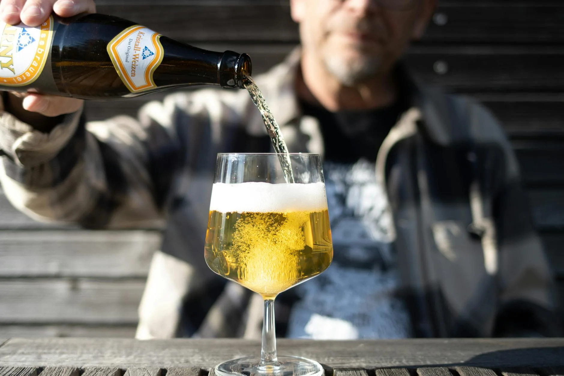 Golden ale being poured into a glass from a homebrew bottle