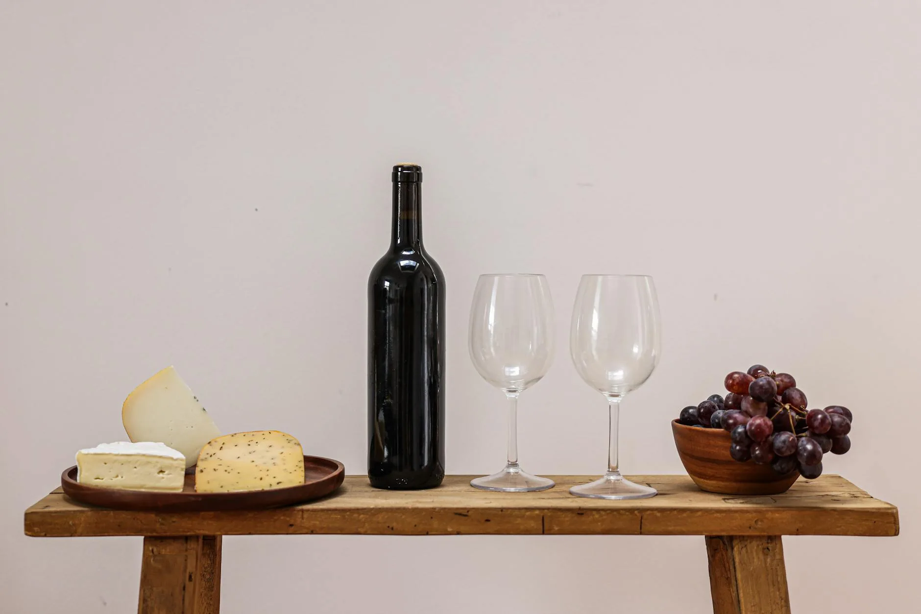 Wine bottle with grapes on a rustic surface