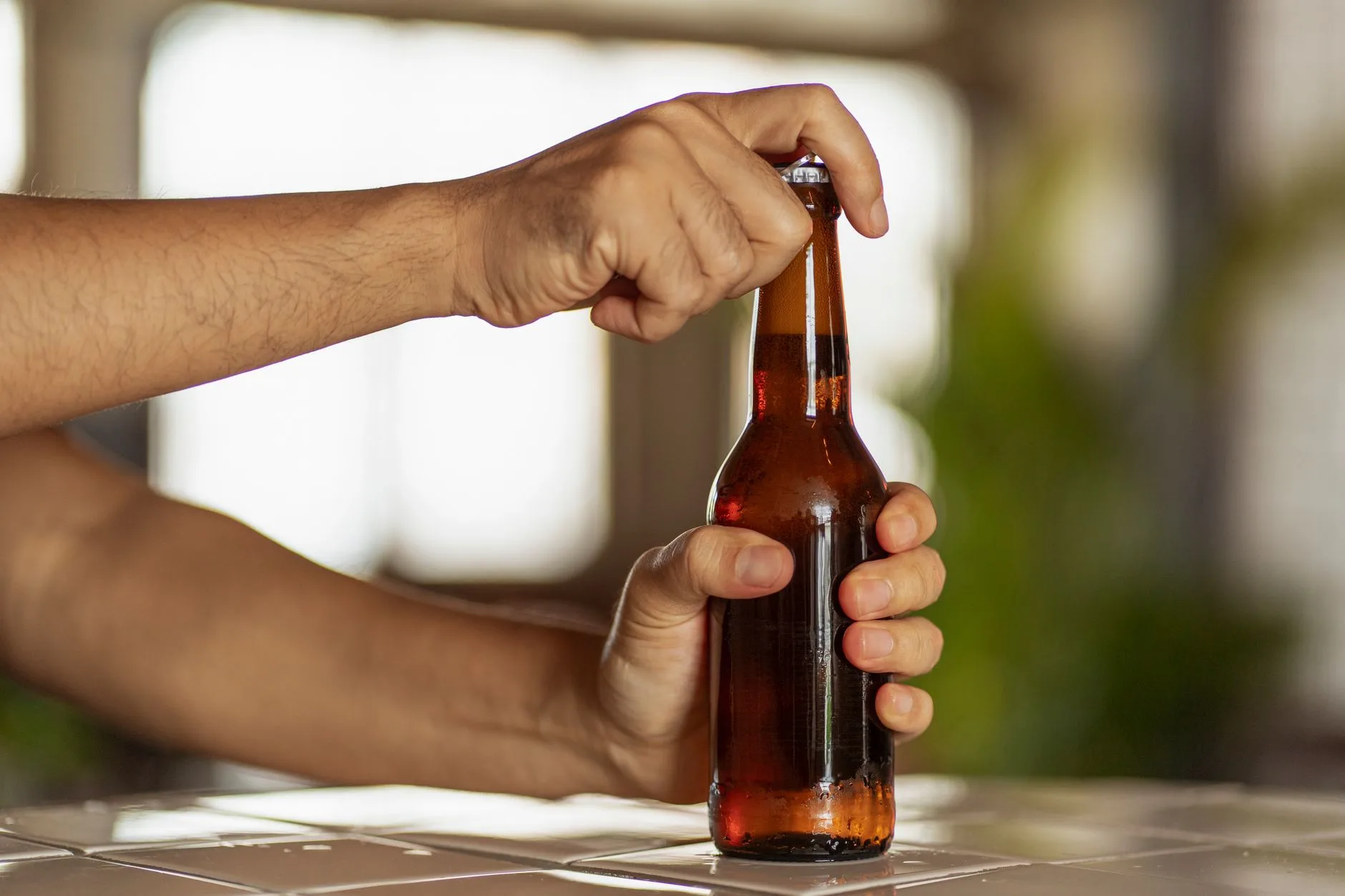 Bottle being opened after homebrew priming sugar carbonation
